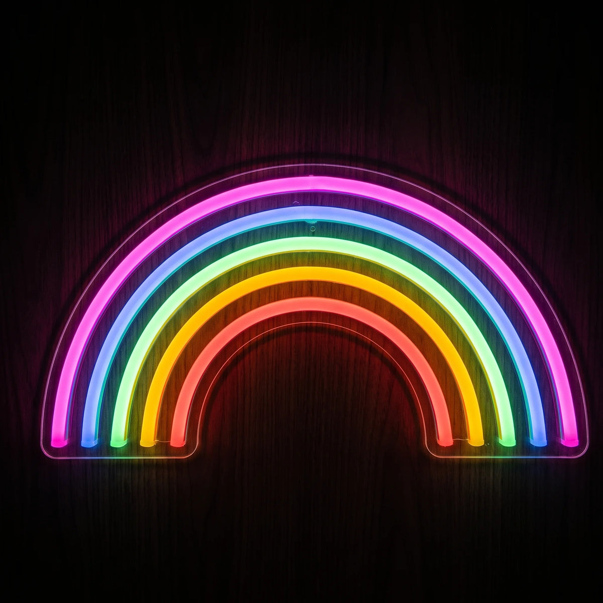 Rainbow arch LED neon sign with pink, blue, green, yellow-orange and red illumination on clear acrylic backing.