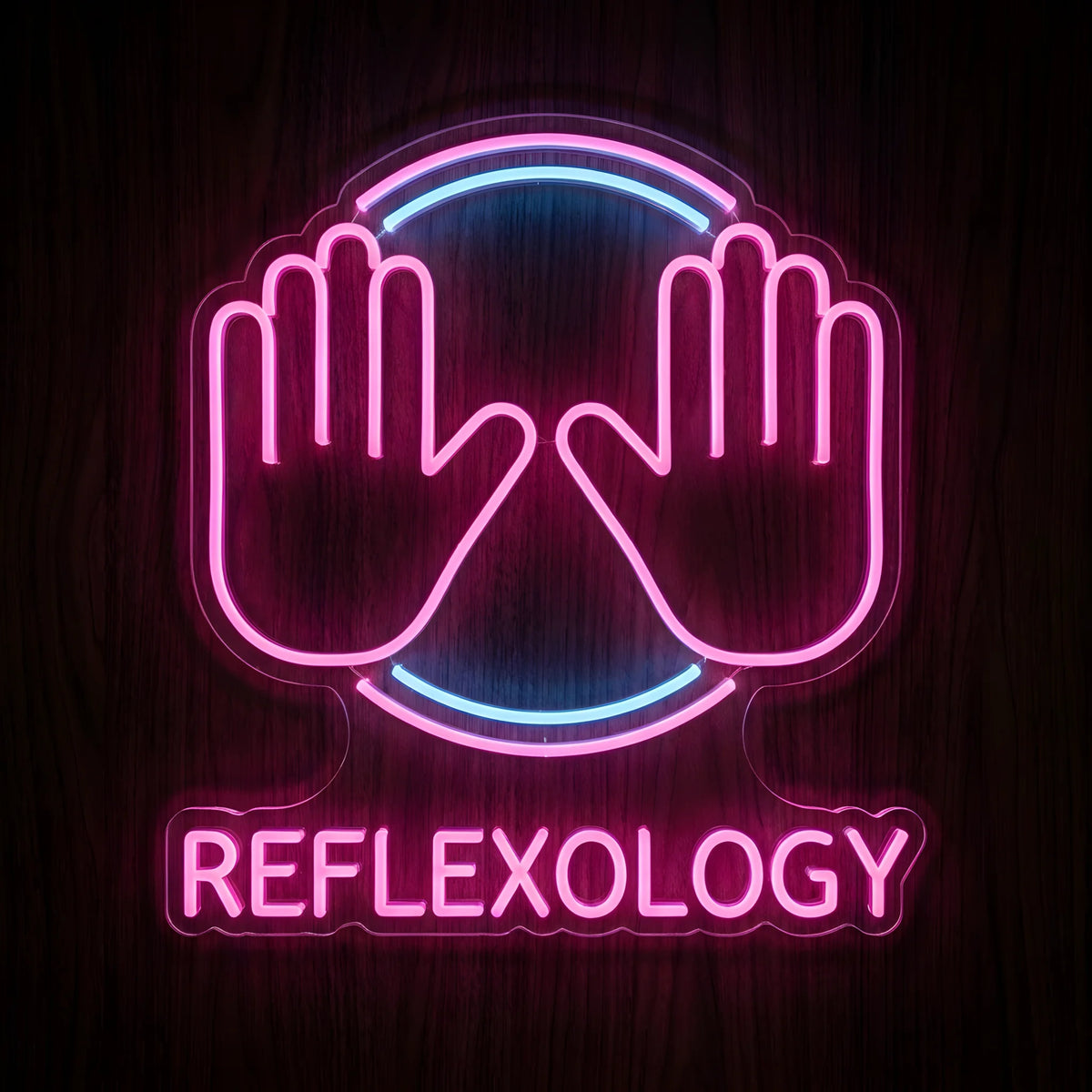 Reflexology Hand Therapy LED Neon Sign featuring two glowing pink hands with pink and blue circular accents and REFLEXOLOGY lettering on clear acrylic against a dark wooden wall.