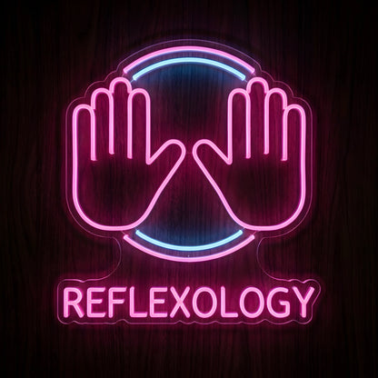 Reflexology Hand Therapy LED Neon Sign featuring two glowing pink hands with pink and blue circular accents and REFLEXOLOGY lettering on clear acrylic against a dark wooden wall.