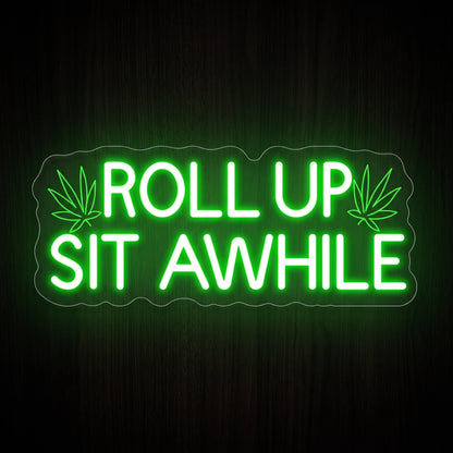 Roll Up Sit Awhile LED neon sign featuring a recreational quote with cannabis leaf accents in bright green and white on a clear acrylic backing.