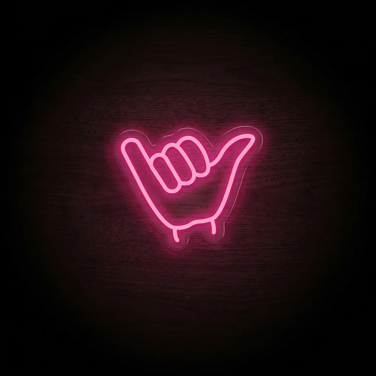 Shaka hand LED neon sign with vibrant pink illumination on clear acrylic backing.