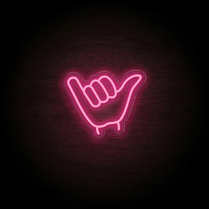 Shaka hand LED neon sign with vibrant pink illumination on clear acrylic backing.