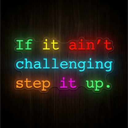 “If it ain’t challenging step it up” LED Neon Sign with multicolored lettering in green, yellow, red, cyan, orange, and magenta on clear acrylic against a dark wood background, suited to gyms and fitness studios.