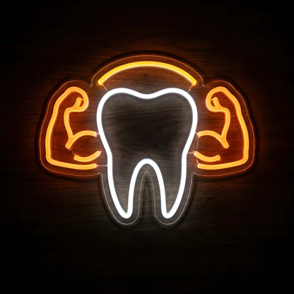 Strong Tooth Dental LED neon sign featuring a cool white tooth outline with orange flexing muscular arms and a golden-orange arch on clear acrylic backing for dental clinic wall decor.