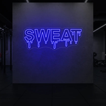 'SWEAT' neon sign glowing in deep blue against a styled interior wall.