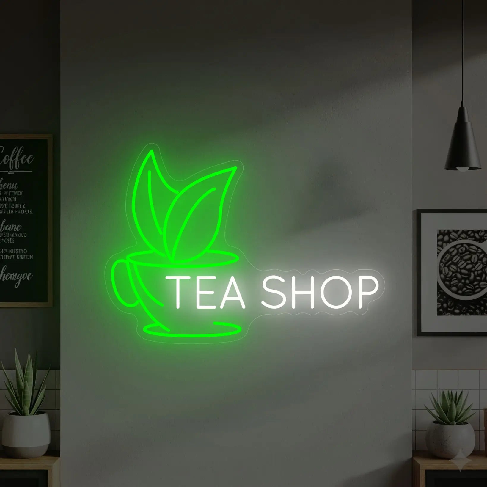 Photo of the 'TEA SHOP' neon sign glowing in cool white and green against a styled interior wall.