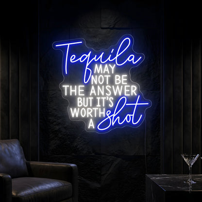 Photo of the 'Tequila May Not Be The Answer But It’s Worth a Shot' neon sign glowing in multi-color against a tequila bar-inspired wall.