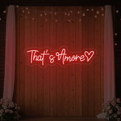 Photo of the 'That's Amore with Heart' neon sign glowing in red against a styled interior wall.