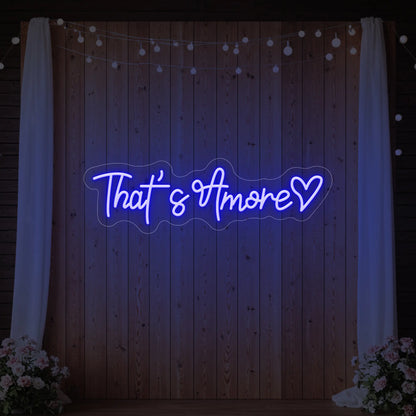 Photo of the 'That's Amore with Heart' neon sign glowing in deep blue against a styled interior wall.