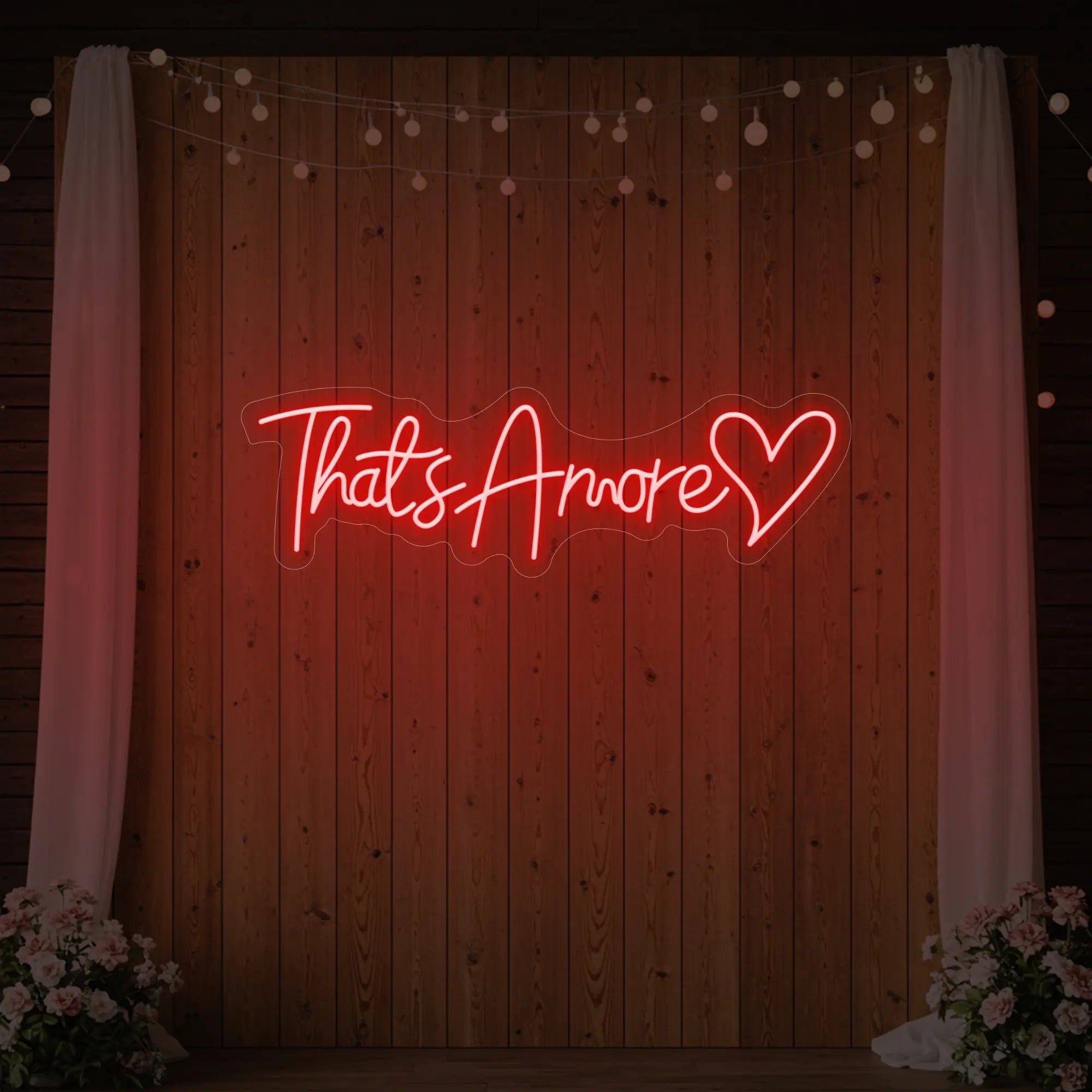 Photo of the 'That's Amore with Heart' neon sign glowing in red against a styled interior wall.