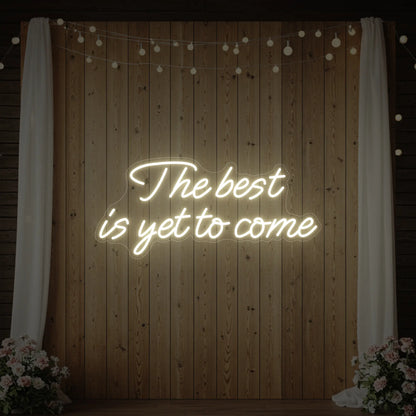  'The Best Is Yet To Come' neon sign glowing in warm white against a styled interior wall.