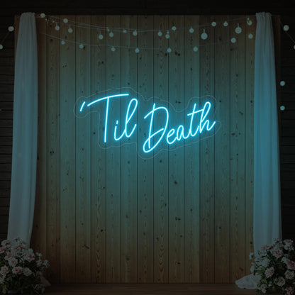 ''Til Death' neon sign glowing in ice blue against a styled interior wall.

