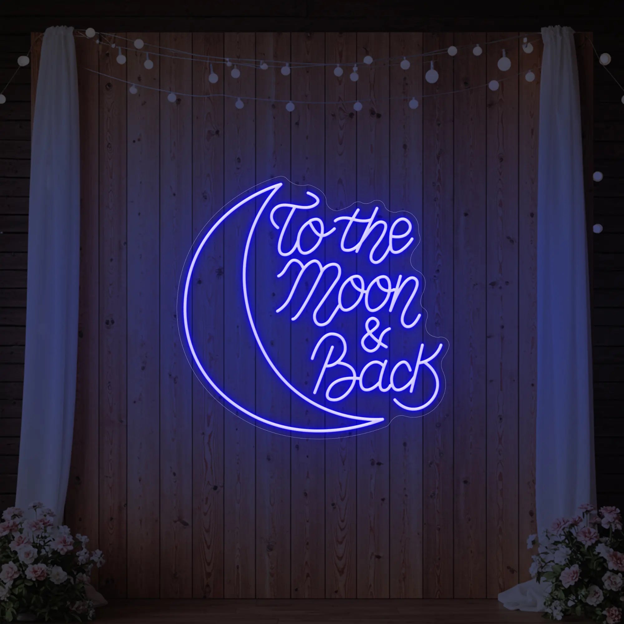  'To The Moon & Back' neon sign glowing in deep blue against a styled interior wall.