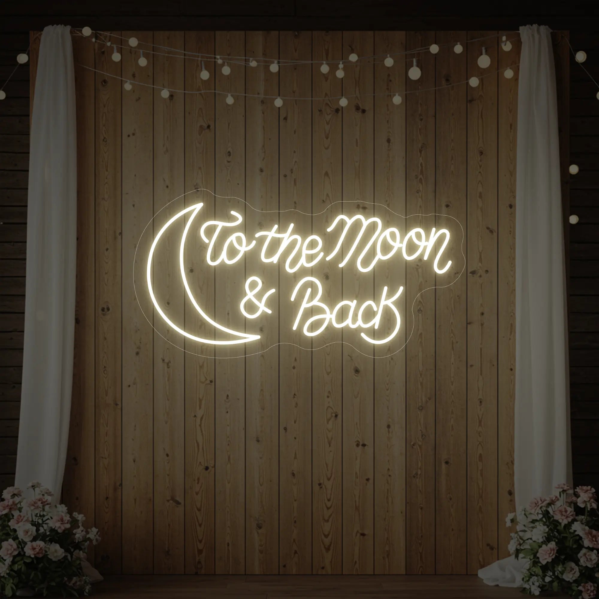  'To The Moon And Back' neon sign glowing in warm white against a styled interior wall.