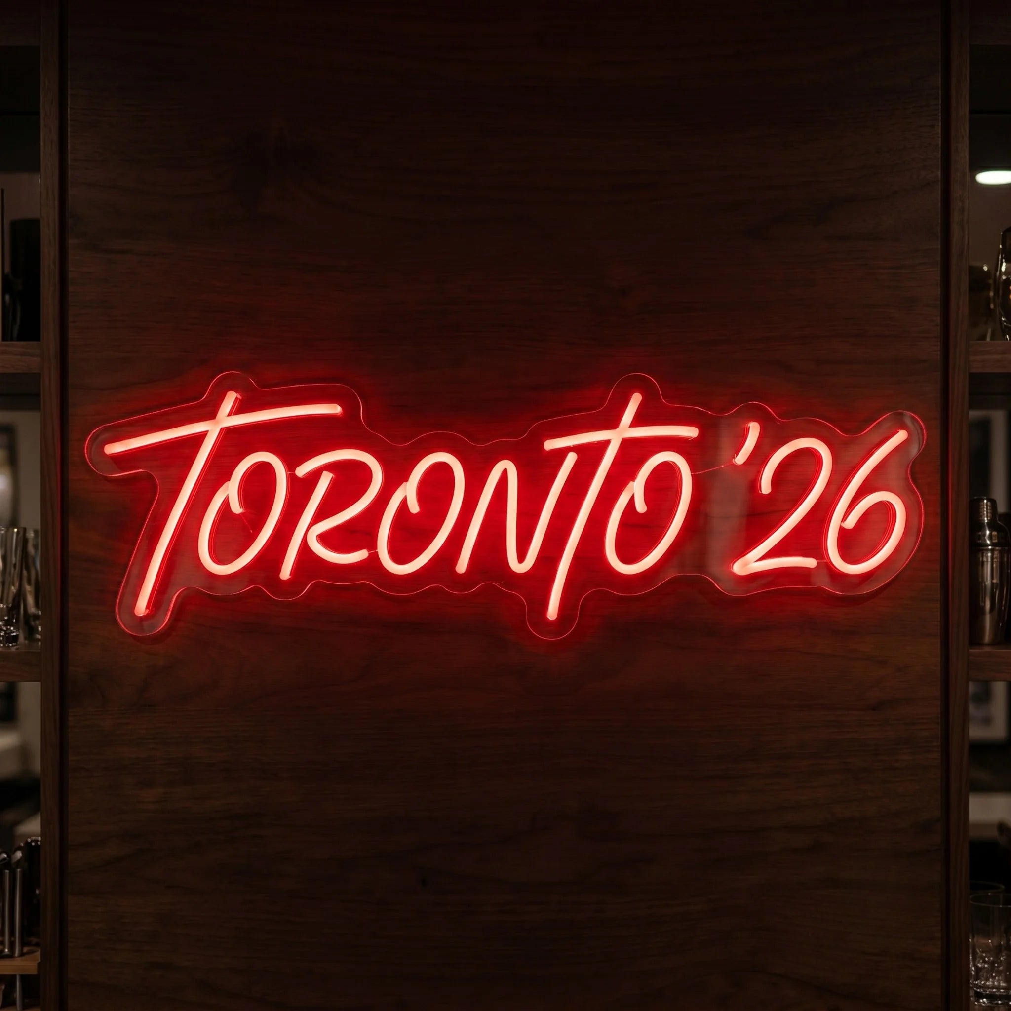 Toronto '26 LED neon sign in bright red script lettering mounted on clear acrylic backing