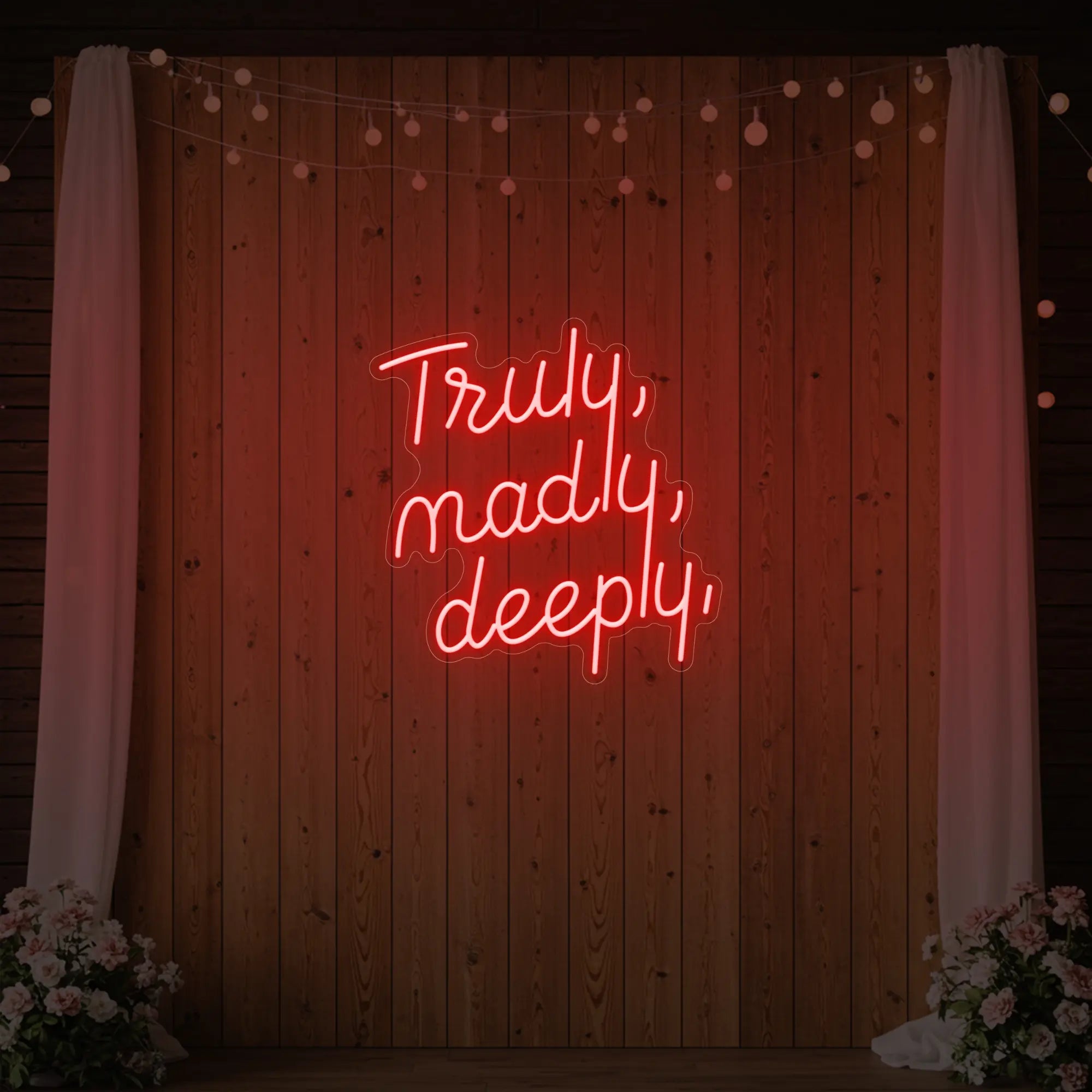  'Truly, Madly, Deeply' neon sign glowing in red against a styled interior wall.