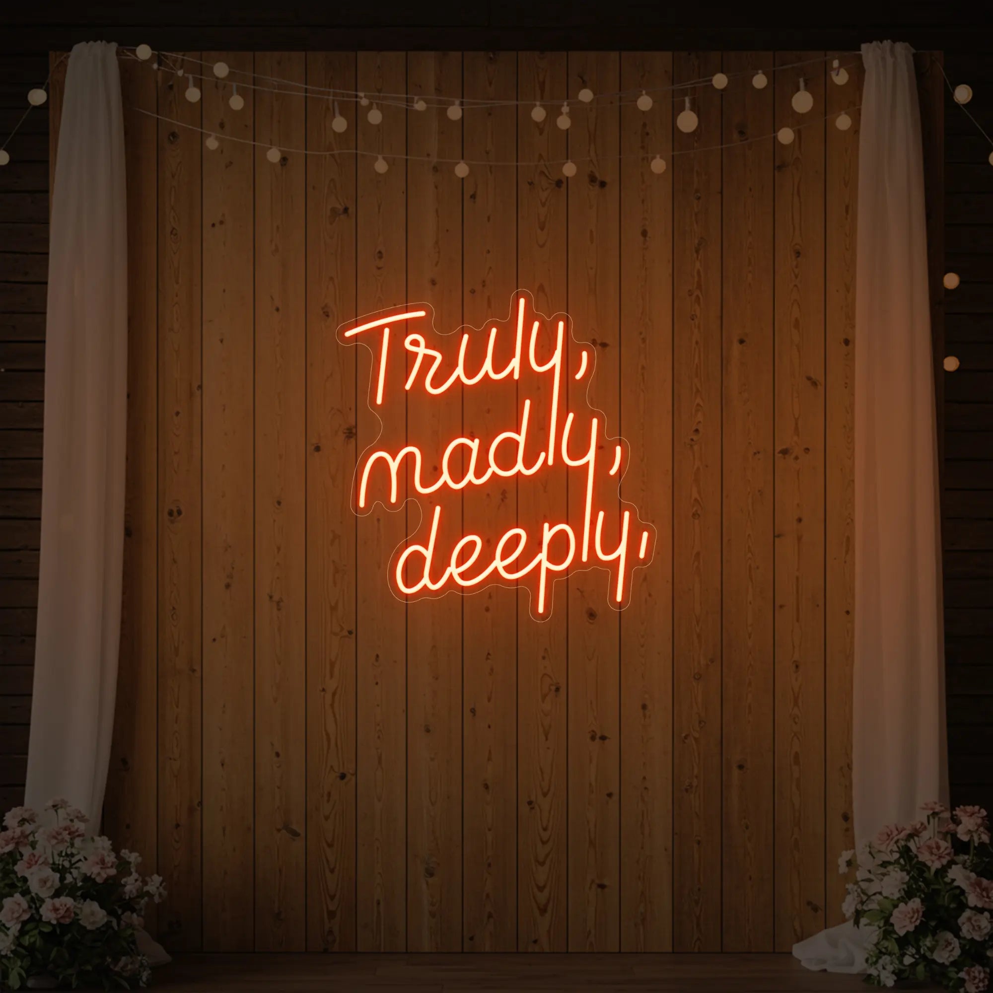  'Truly, Madly, Deeply' neon sign glowing in golden yellow against a styled interior wall.