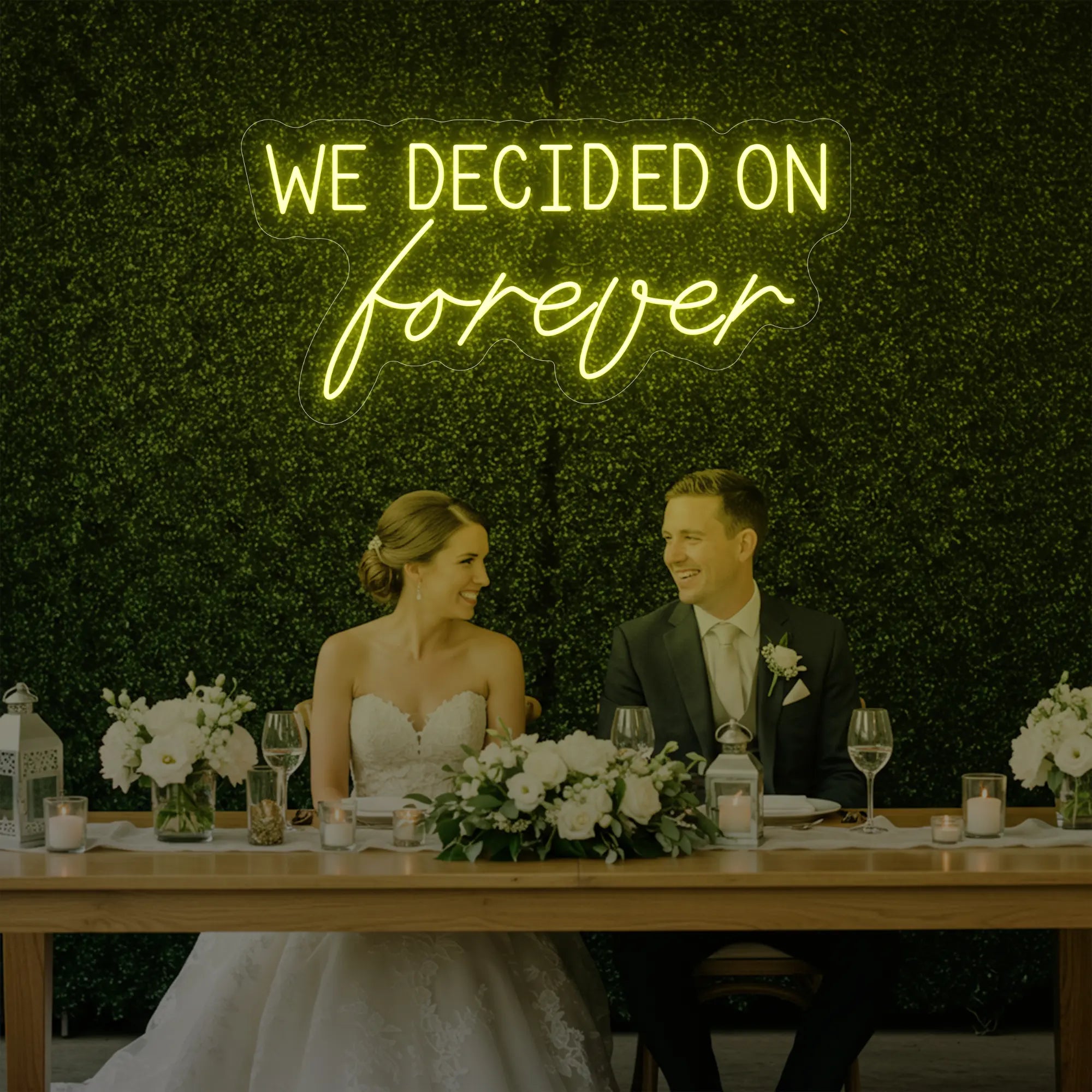  'We Decided On Forever' neon sign glowing in lemon yellow against a styled interior wall.