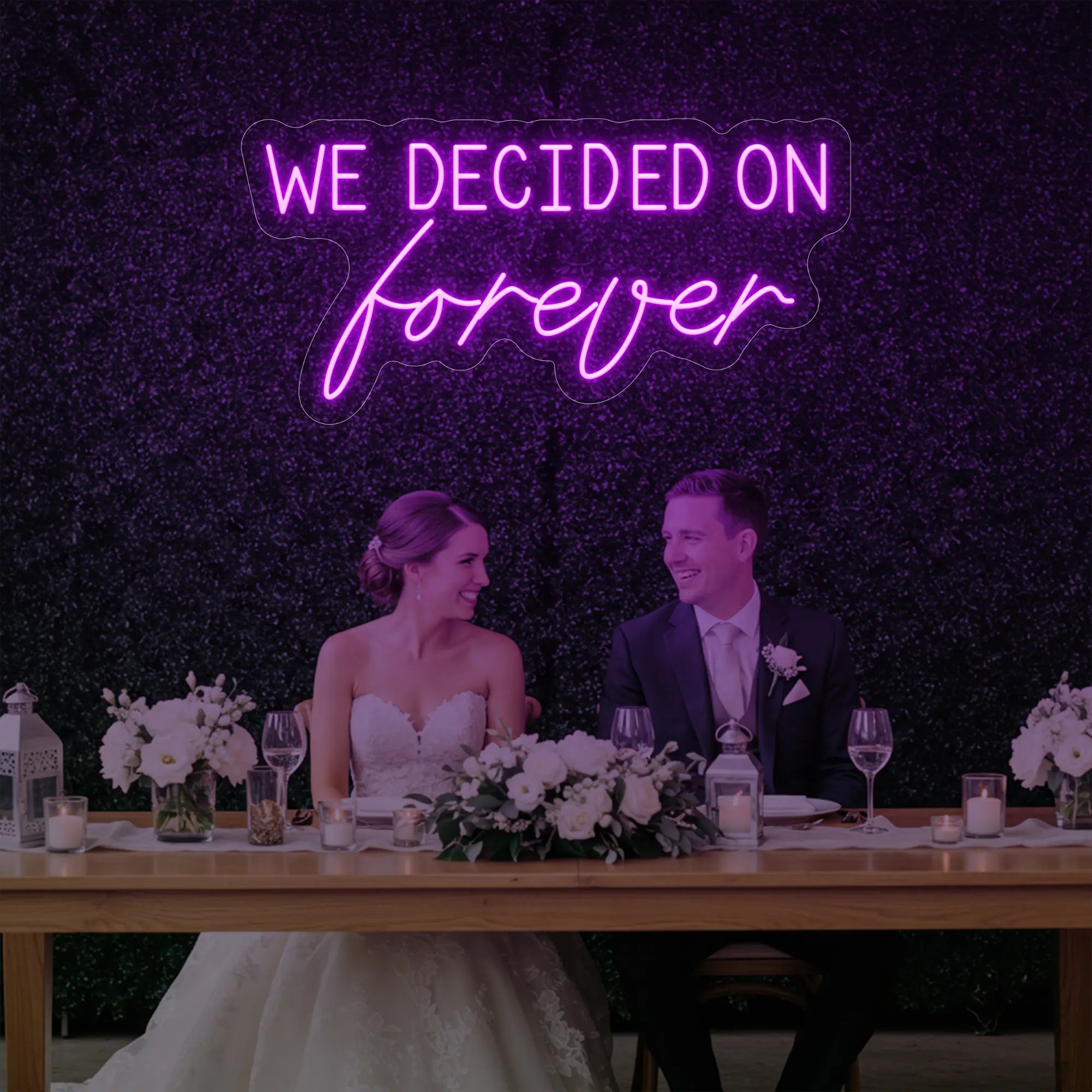  'We Decided On Forever' neon sign glowing in deep pink against a styled interior wall.
