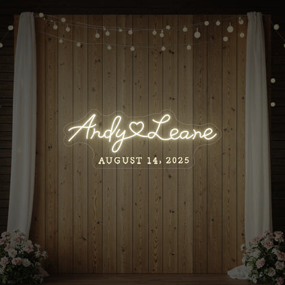 Photo of the 'Wedding First Names Custom Neon Sign' neon sign glowing in warm white against a styled interior wall.