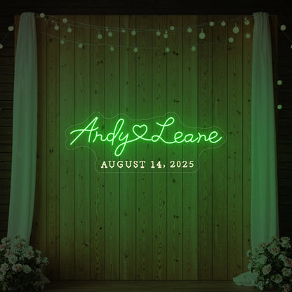 Photo of the 'Wedding First Names Custom Neon Sign' neon sign glowing in green against a styled interior wall.