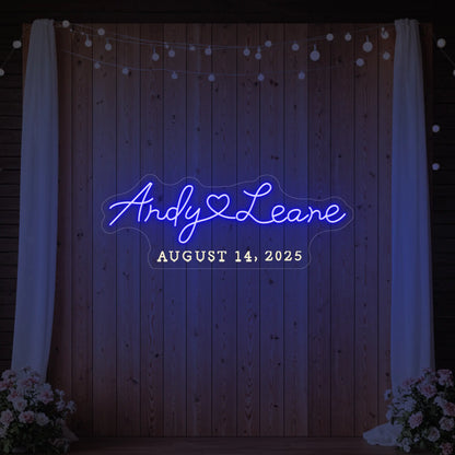 Photo of the 'Wedding First Names Custom Neon Sign' neon sign glowing in deep blue against a styled interior wall.