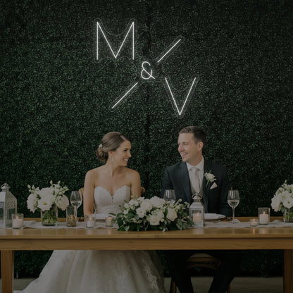 Photo of the 'Wedding Initials Custom Neon Sign V1' neon sign glowing in cool white against a styled interior wall.