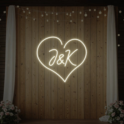 Photo of the 'Wedding Initials Custom Neon Sign V5' neon sign glowing in warm white against a styled interior wall.