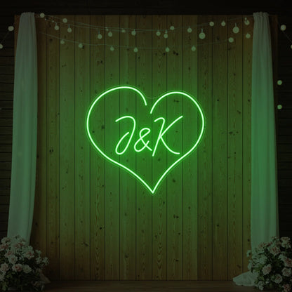 Photo of the 'Wedding Initials Custom Neon Sign V5' neon sign glowing in green against a styled interior wall.
