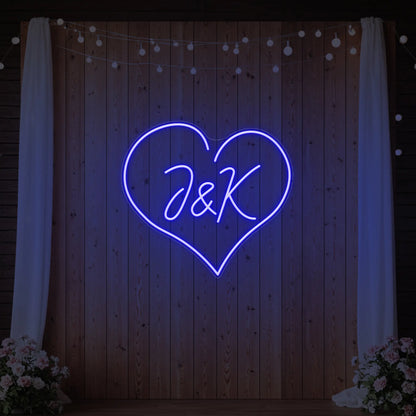 Photo of the 'Wedding Initials Custom Neon Sign V5' neon sign glowing in deep blue against a styled interior wall.