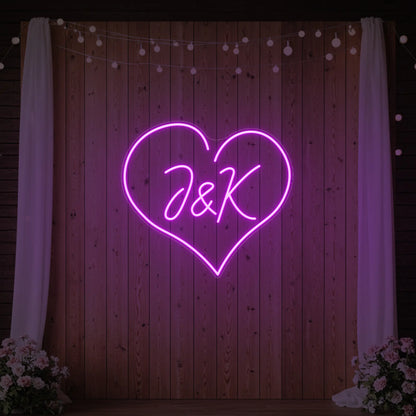 Photo of the 'Wedding Initials Custom Neon Sign V5' neon sign glowing in deep pink against a styled interior wall.