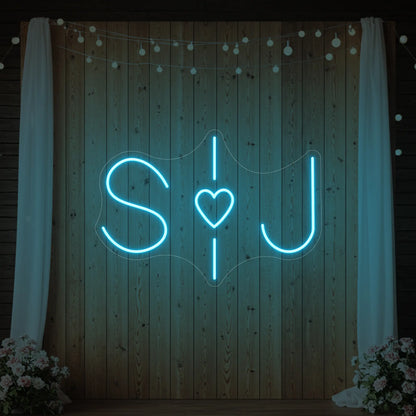 Photo of the 'Wedding Initials Custom Neon Sign V6' neon sign glowing in ice blue against a styled interior wall.