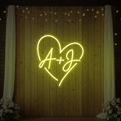 Photo of the 'Wedding Initials Custom Neon Sign V7' neon sign glowing in lemon yellow against a styled interior wall.