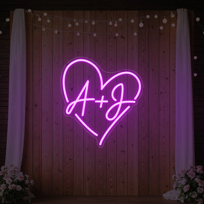 Photo of the 'Wedding Initials Custom Neon Sign V7' neon sign glowing in deep pink against a styled interior wall.