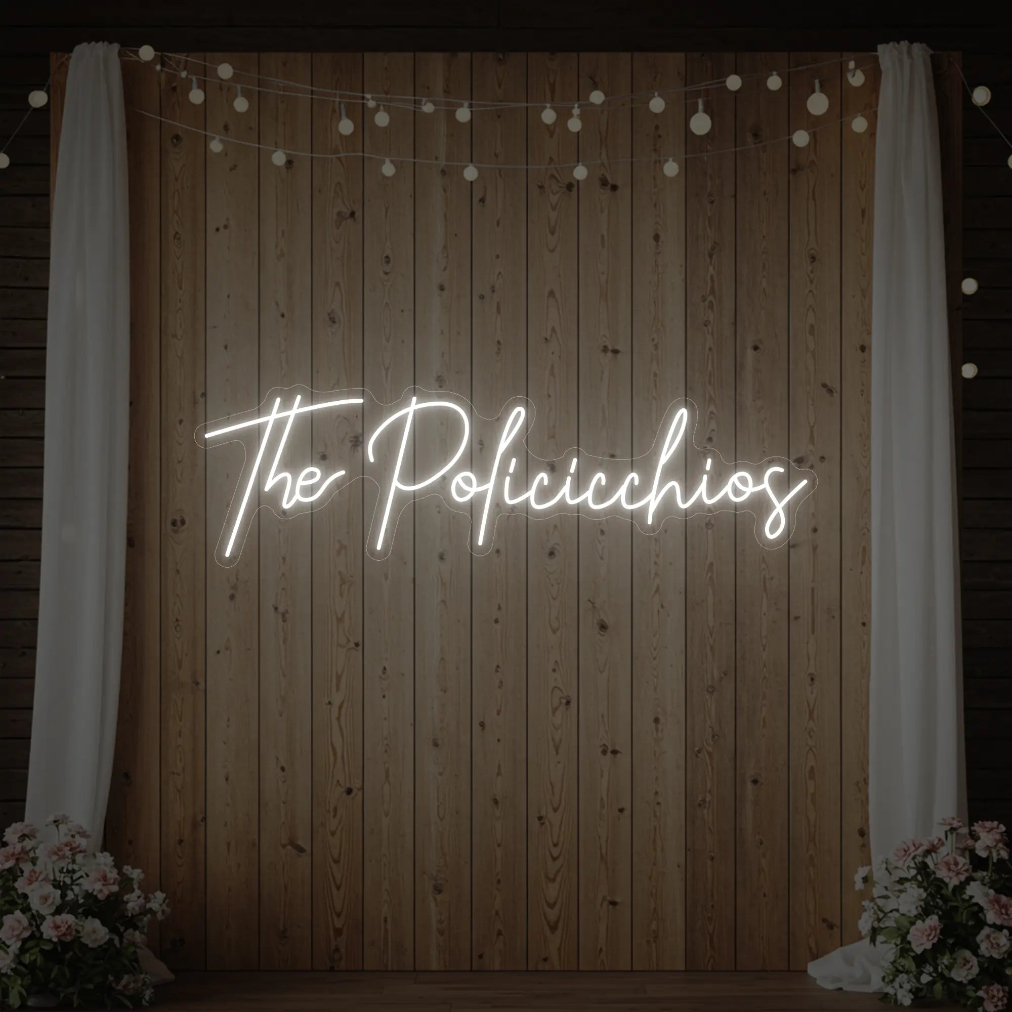 Photo of the 'Wedding Last Names Custom Neon Sign V7' neon sign glowing in cool white against a styled interior wall.