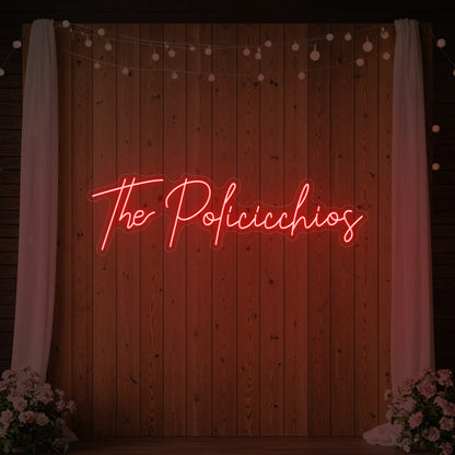 Photo of the 'Wedding Last Names Custom Neon Sign V7' neon sign glowing in red against a styled interior wall.