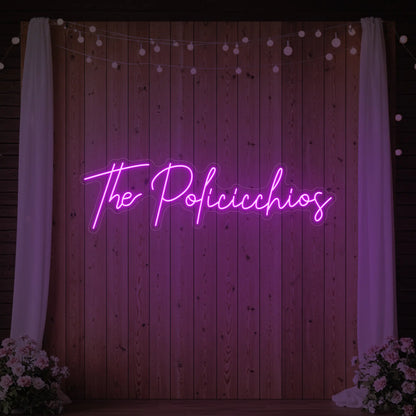 Photo of the 'Wedding Last Names Custom Neon Sign V7' neon sign glowing in deep pink against a styled interior wall.