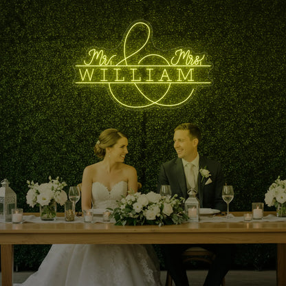 Photo of the 'Wedding Last Names Custom Neon Sign V3' neon sign glowing in lemon yellow against a styled interior wall.