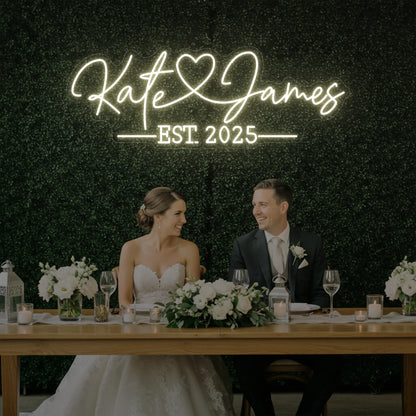 Photo of the 'Wedding Names Custom Neon Sign' neon sign glowing in warm white against a styled interior wall.