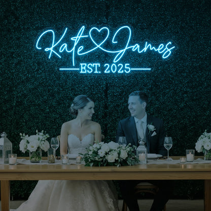 Photo of the 'Wedding Names Custom Neon Sign' neon sign glowing in ice blue against a styled interior wall.