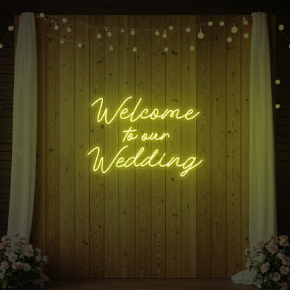  'Welcome To Our Wedding' neon sign glowing in lemon yellow against a styled interior wall.