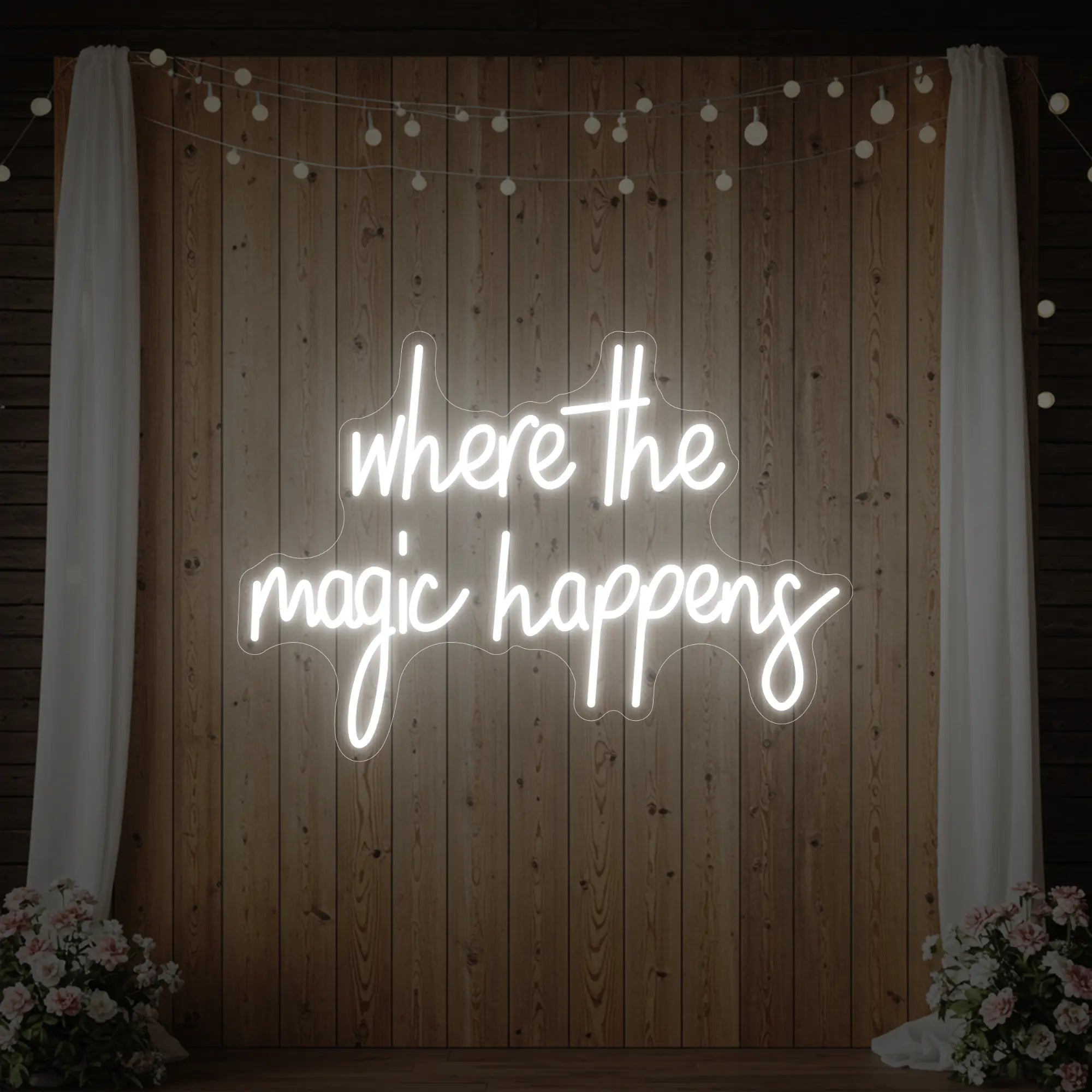  'Where The Magic Happens' neon sign glowing in cool white against a styled interior wall.