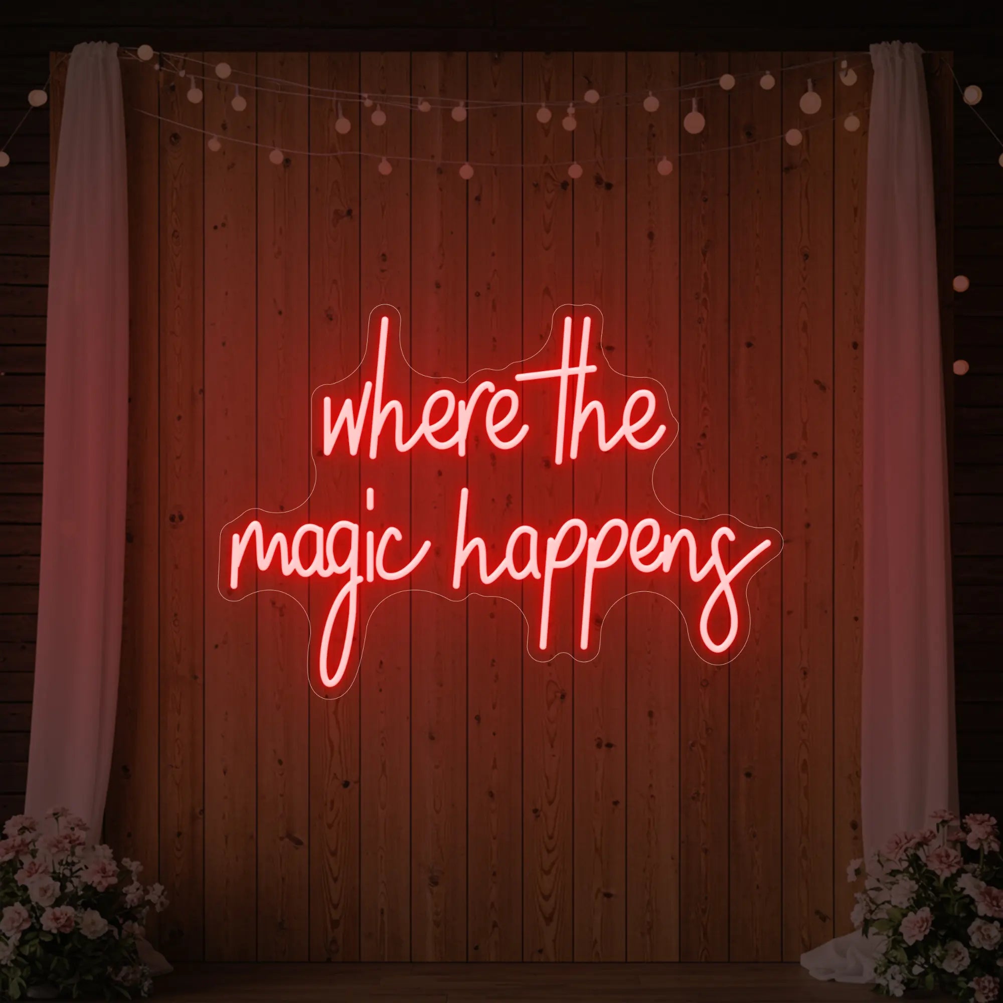  'Where The Magic Happens' neon sign glowing in red against a styled interior wall.