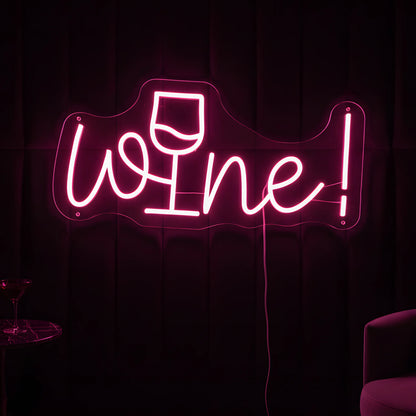 Photo of the 'Wine!' neon sign glowing in pink against a stylish wine bar-inspired wall.
