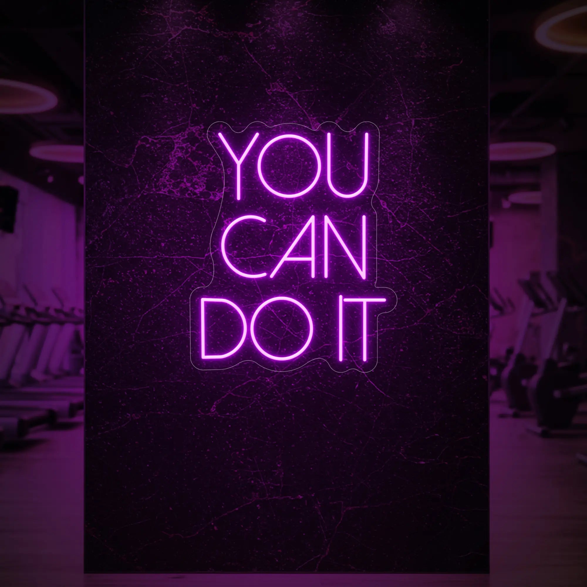 Photo of the 'YOU CAN DO IT' neon sign glowing in deep pink against a styled interior wall.
