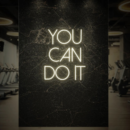  'YOU CAN DO IT' neon sign glowing in warm white against a styled interior wall.