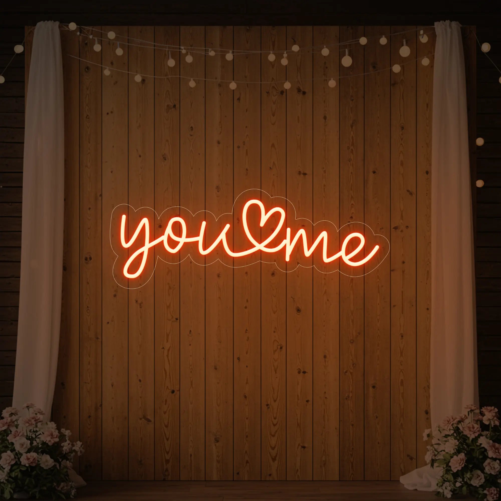  'You Heart Me' neon sign glowing in golden yellow against a styled interior wall.