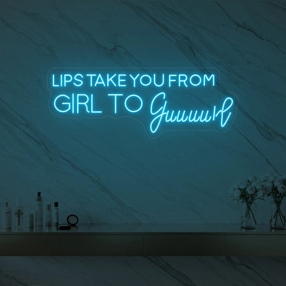 Photo of the 'LIPS TAKE YOU FROM GIRL TO Guuuurl' neon sign glowing in ice blue against a styled interior wall.